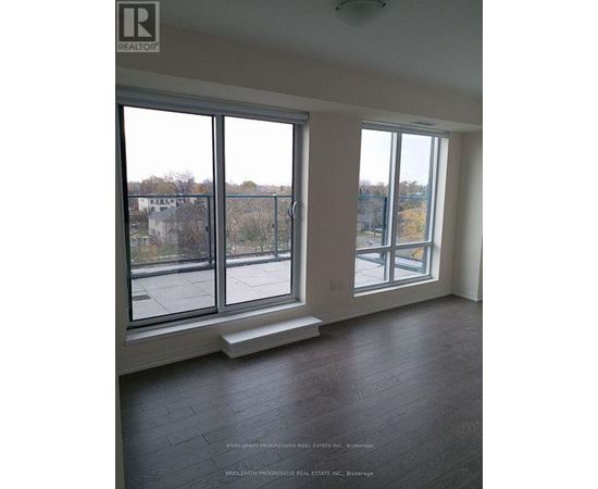 A large empty room with a view of the outside through the windows.