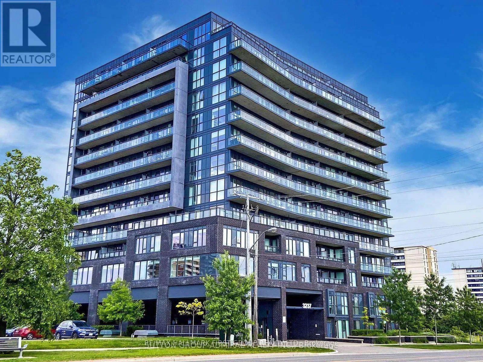 A tall building with a parking garage in front of it.