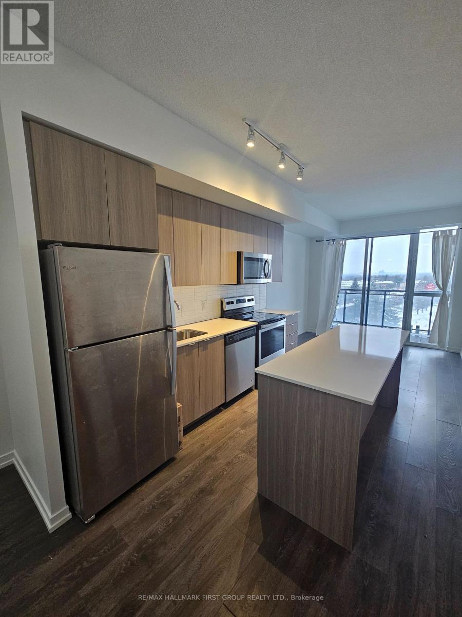 A kitchen with a refrigerator, sink, and countertops.