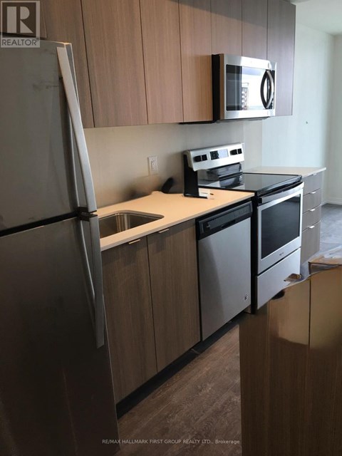 A kitchen with a refrigerator, microwave, oven and dishwasher.