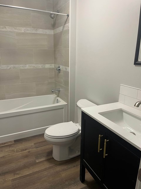 A white toilet sits next to a white sink in a bathroom.