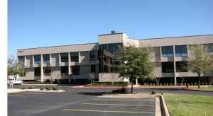 A large building with a parking lot in front.