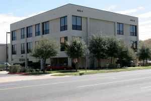 A large building with a parking lot in front.