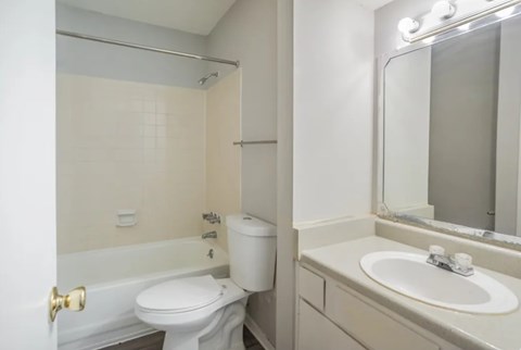 A white toilet sits next to a white sink in a bathroom.