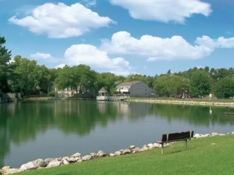 A serene park with a bench and a lake.