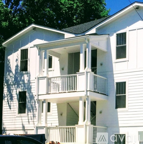 A white two-story building with balconies and windows.