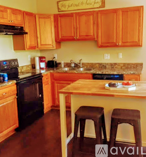 A kitchen with wooden cabinets and a black stove top oven.