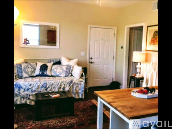 A living room with a couch, coffee table, and lamp.