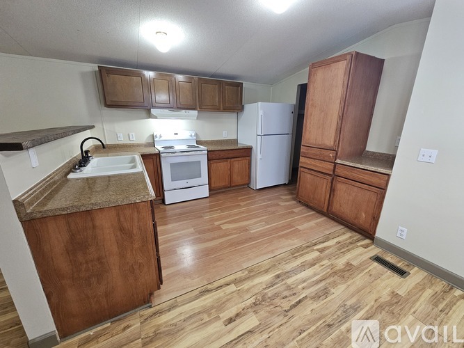 A kitchen with wooden floors and cabinets.