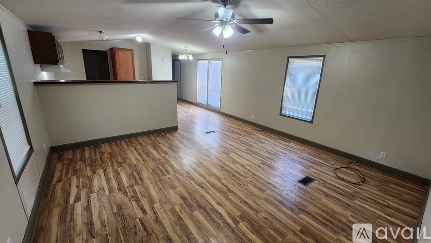 A room with wooden flooring and a ceiling fan.