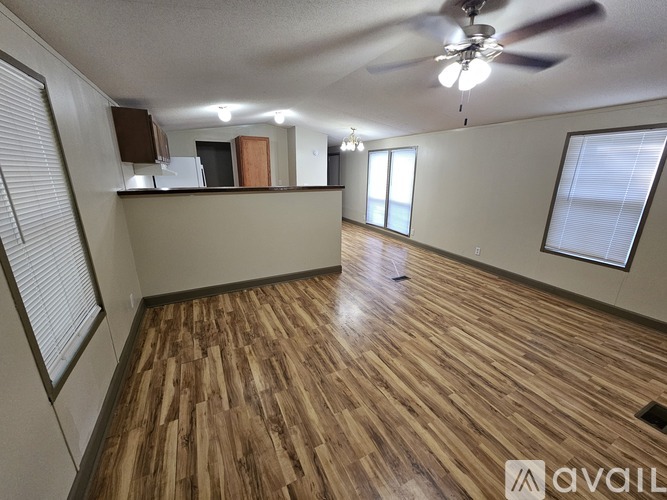 A room with wooden flooring and a ceiling fan.