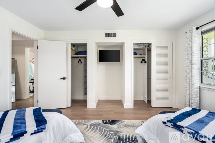 A bedroom with two beds and a television in the corner.