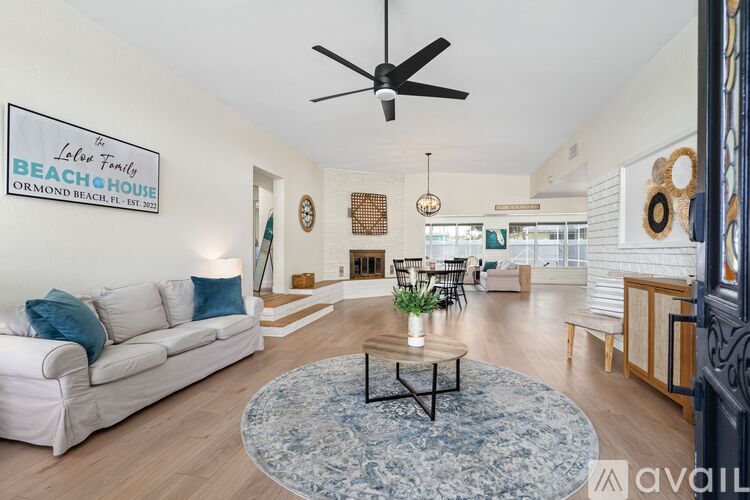 A living room with a white couch and a rug on the floor.