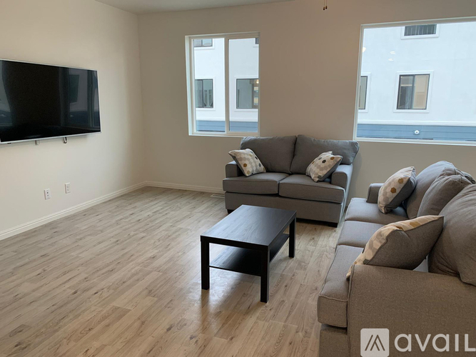 A living room with a couch, a coffee table, and a television.