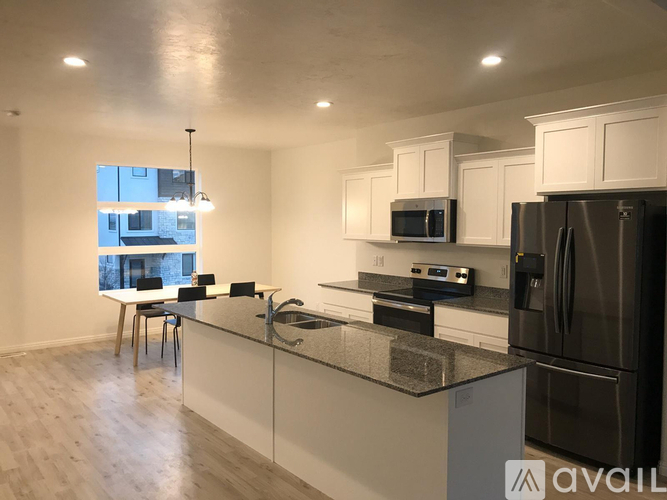 A kitchen with a black refrigerator and a black stove top oven.