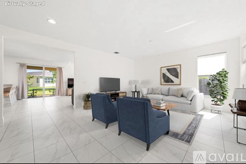 A living room with a blue chair and a white couch.