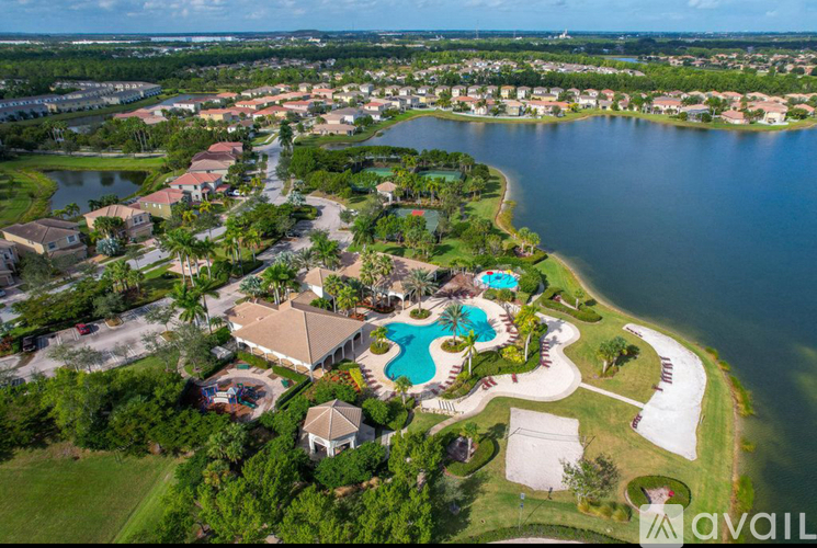 A bird's eye view of a residential area with a swimming pool and a lake.