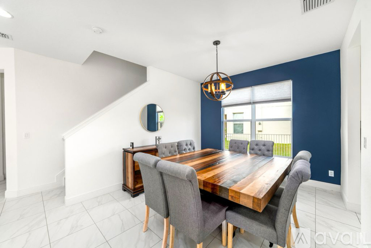 A dining room with a wooden table and grey chairs.