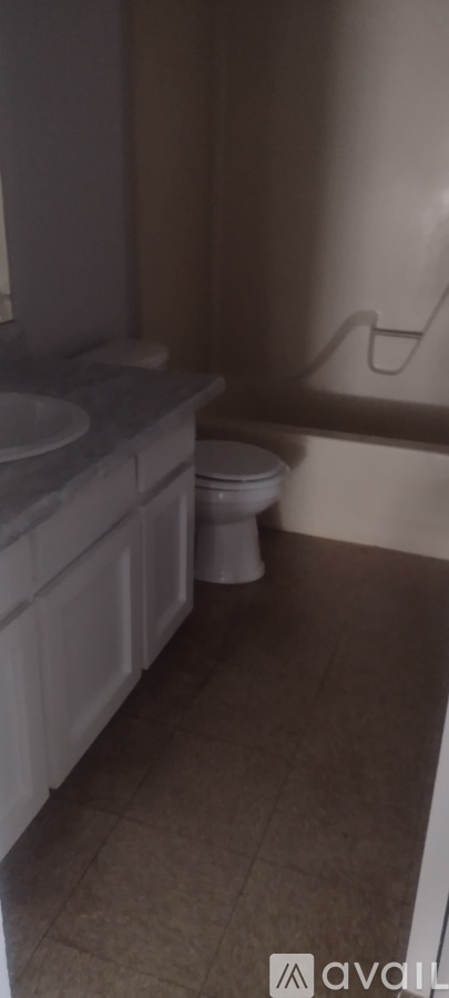 A bathroom with a toilet, sink, and bathtub.