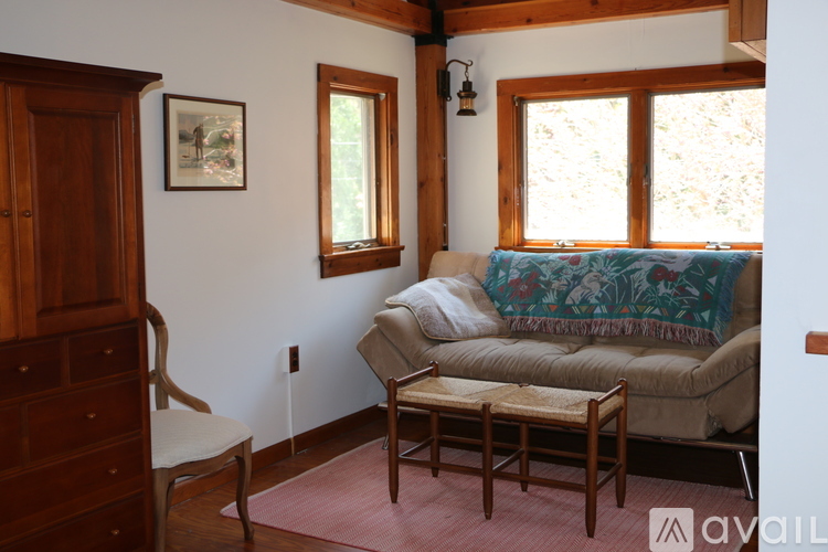 A living room with a couch, chair, and a painting on the wall.
