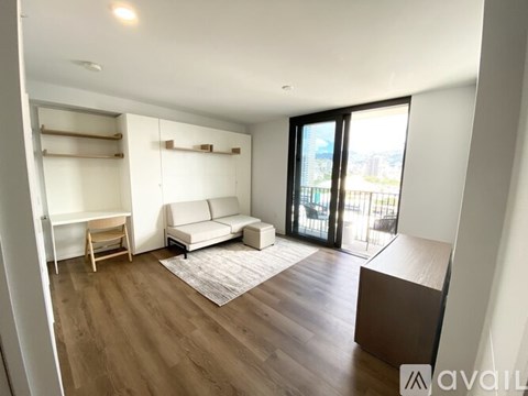 A living room with a white couch and a wooden floor.