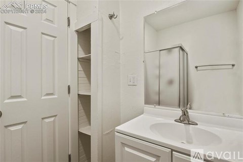A white bathroom with a sink, mirror, and medicine cabinet.