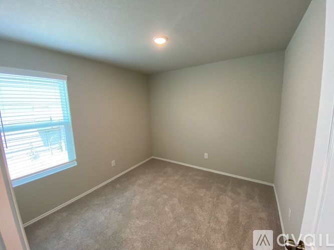A room with a window and carpeted floor.