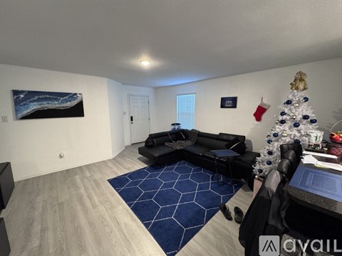 A living room with a Christmas tree and a painting on the wall.