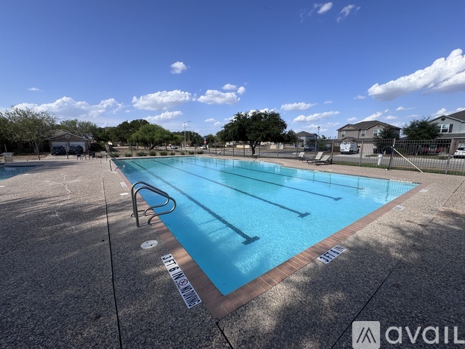 A large outdoor swimming pool with a blue tinted water.
