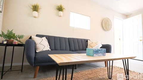A living room with a blue couch and a wooden coffee table.
