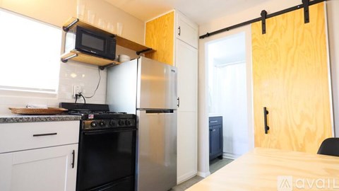 A kitchen with a black oven and a microwave above it.