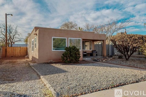 A house with a brown exterior and a gravel driveway is available for sale.