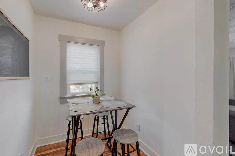 A small dining area with a round table and four chairs.