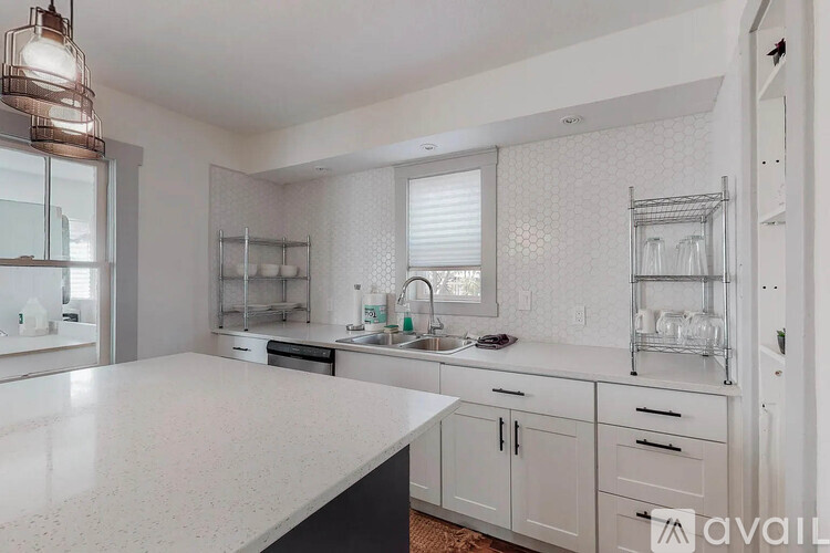A kitchen with white cabinets and a white countertop.
