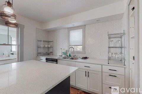 A kitchen with white cabinets and a white countertop.