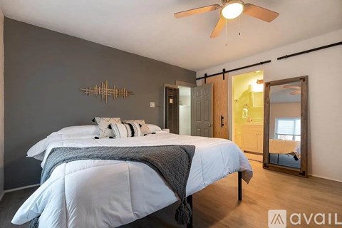 A bedroom with a bed and a ceiling fan.