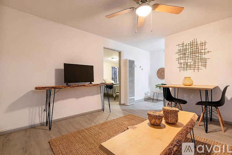 A room with a television, a table, and chairs.