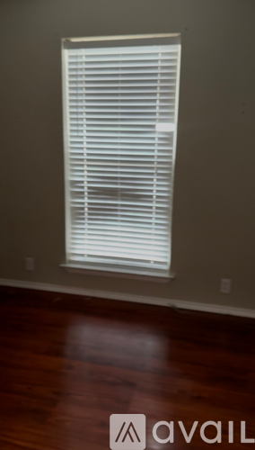 A room with a window covered in blinds.