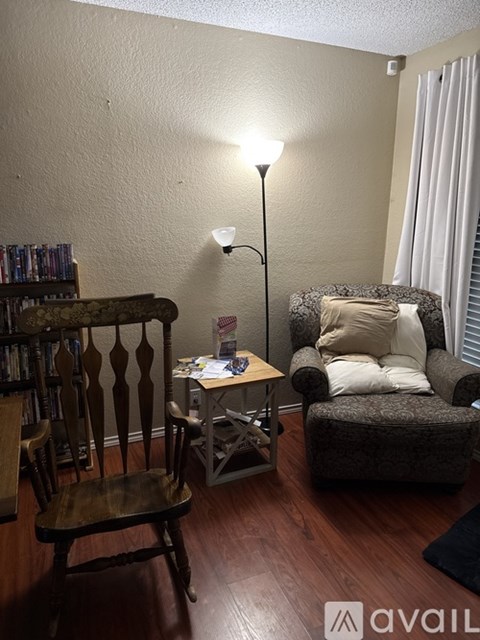 A living room with a chair, a table, and a lamp.