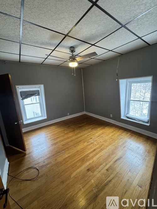 A room with wooden flooring and a ceiling fan.