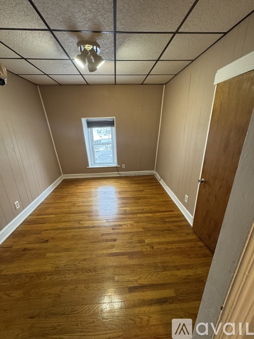 A room with wooden floors and a window.