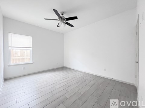 A room with a ceiling fan and a window.