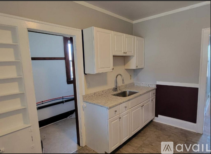 A kitchen with white cabinets and a sink.