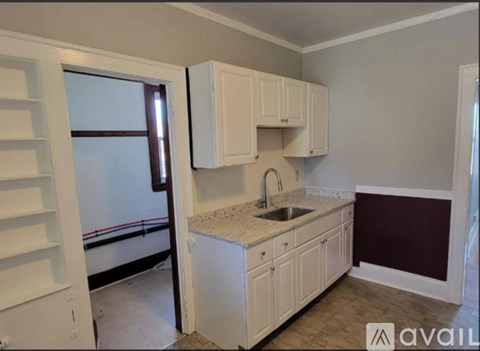A kitchen with white cabinets and a sink.