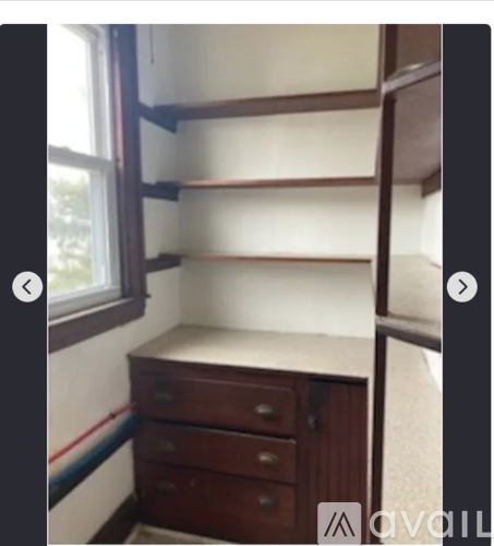 A small room with a desk and drawers.