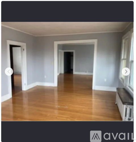 A room with wooden flooring and white walls.