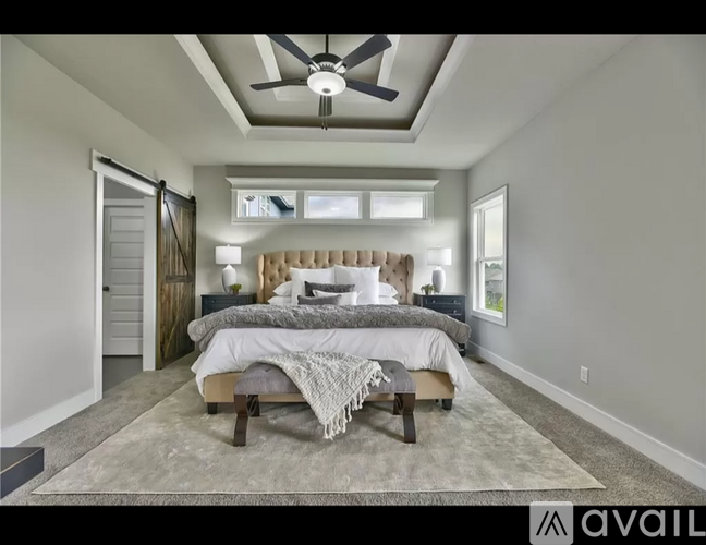 A bedroom with a large bed and a ceiling fan.