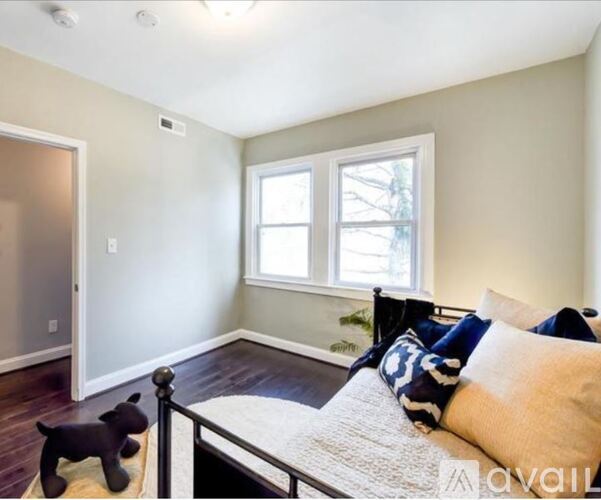A bedroom with a bed, pillows, and a toy dog.
