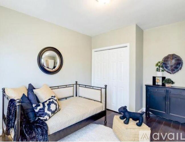 A bedroom with a bed, a dresser, and a mirror on the wall.