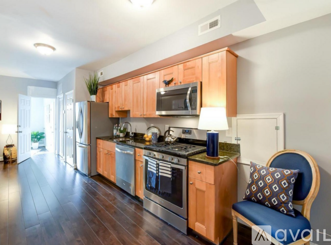 A kitchen with wooden cabinets and a blue chair.